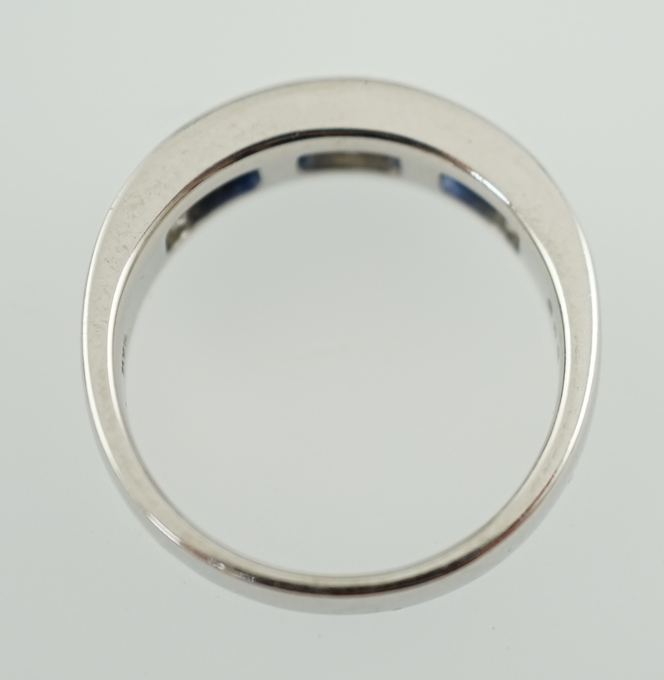 A modern 14k white gold, three stone diamond and four stone sapphire half hoop ring
